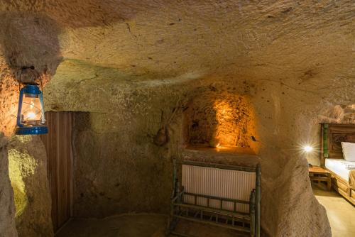 a stone cave with a bed in a room at Atilla's Cave Hotel in Nevsehir