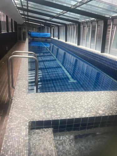 an empty swimming pool in a building with blue tiles at Museum Apartment in Wellington
