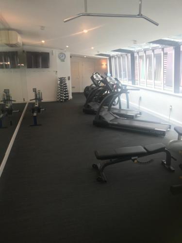 a gym with several treadmills and elliptical machines at Museum Apartment in Wellington