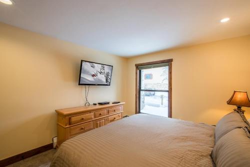 a bedroom with a bed and a tv on the wall at Breakaway West - Studio, 2,3 Bedrooms by Vail Realty in Vail