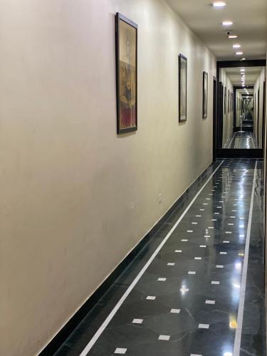an empty hallway with paintings on the walls of a building at Shivam Hotels in Kolkata