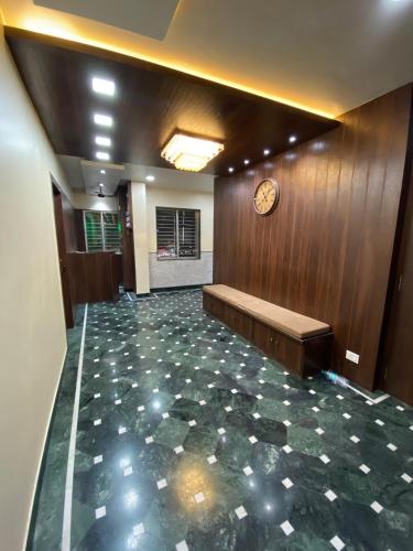 a lobby with a clock on the wall and a bench at Shivam Hotels in Kolkata