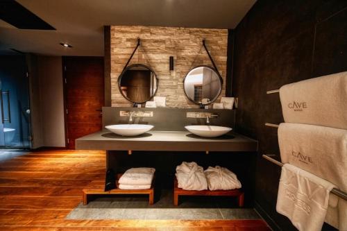 a bathroom with two sinks and two mirrors at Cave Hotel near Canterbury in Faversham