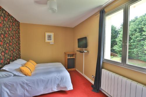 1 dormitorio con cama y ventana en Logis Hotel Des Grands Vins, en Fleurie