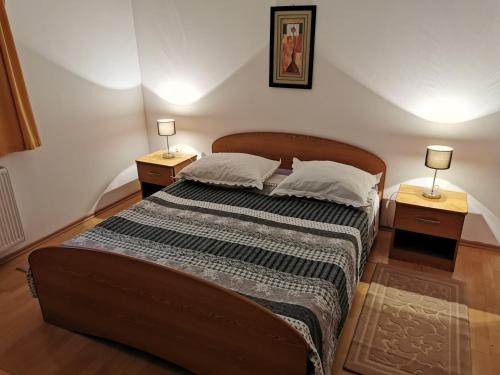 a bedroom with a large bed with two night stands at Apartmani Prova in Tisno