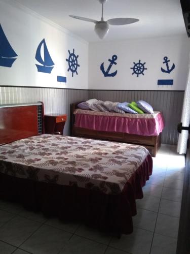 1 dormitorio con 2 camas y letreros en la pared en Apartamento na praia do Itarare en São Vicente