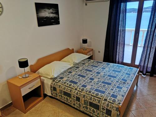a bedroom with a bed with a blue and white comforter at Apartmani Prova 4 in Tisno