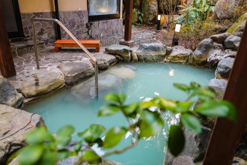 a pool of water with a bench next to it at Ajisai Onsen Ryokan - Award Winning Private Open Air Onsen in Hakone