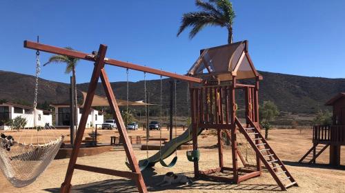 a playground with a slide and a swing at Villa Victoria in Valle de Guadalupe