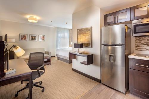 a hotel room with a desk and a refrigerator at Staybridge Suites Silao by IHG in Silao