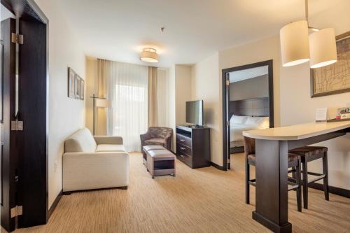 a hotel room with a desk and a bedroom at Staybridge Suites Silao by IHG in Silao