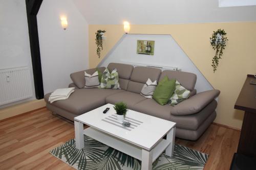 a living room with a couch and a table at Gutshof Kämmerich - Fewo "Siebenschläferhöhle" in Altkalen