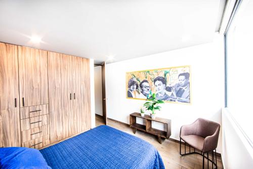 - une chambre avec un lit bleu et une chaise dans l'établissement Modern & Renovated Apartment with Private Patio in Tacuba - Legaria, à Mexico