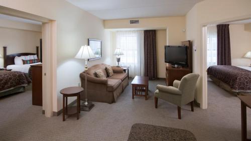 a hotel room with a bed and a living room at Staybridge Suites Buffalo by IHG in Buffalo