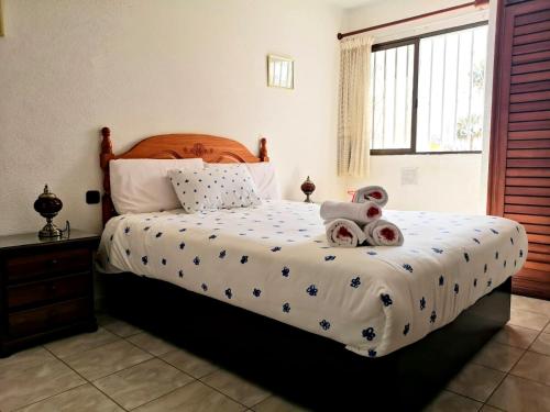 Fantastic Bungalow Playa de Las Américas في أرونا: غرفة نوم مع سرير مع دمية دب عليها