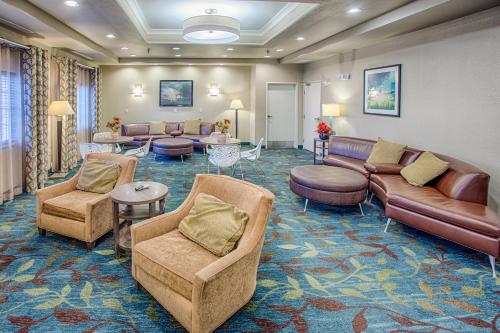 uma sala de espera com sofás, cadeiras e mesas em Candlewood Suites Fargo-North Dakota State University, an IHG Hotel em Fargo