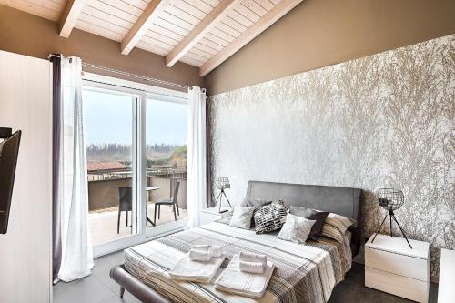 デセンツァーノ・デル・ガルダにあるMarylindaのベッドと大きな窓のある寝室