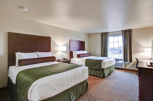 Ένα ή περισσότερα κρεβάτια σε δωμάτιο στο Cobblestone Hotel & Suites Pulaski/Green Bay