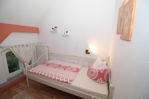 a small room with a bed and a window at Gutshof Kämmerich - Fewo "Siebenschläferhöhle" in Altkalen