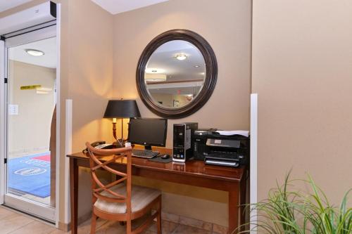 an office with a desk with a computer and a mirror at Candlewood Suites Elmira Horseheads by IHG in Horseheads