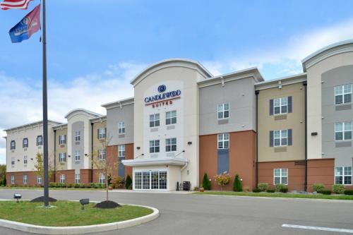 an exterior view of a hotel with a flag at Candlewood Suites Elmira Horseheads by IHG in Horseheads