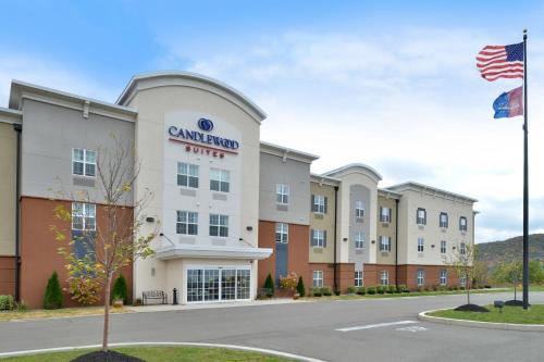 an exterior view of a grand hotel with an american flag at Candlewood Suites Elmira Horseheads by IHG in Horseheads