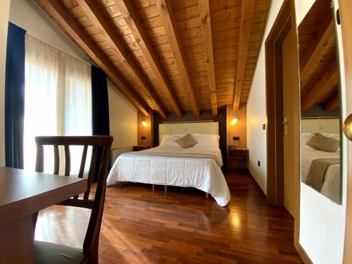 a bedroom with two beds and a table and a desk at Sole della Franciacorta - Hotel & Restaurant in Capriolo