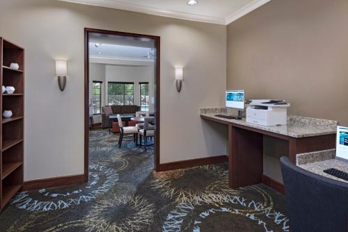 a hotel room with a reception desk and a mirror at Staybridge Suites Austin Northwest by IHG in Austin