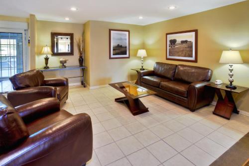 a living room with leather couches and a table at Candlewood Suites Killeen - Fort Cavazos Area by IHG in Killeen