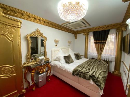 a bedroom with a bed with a mirror and a chandelier at President Luxury in Ploieşti