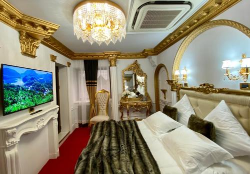 a bedroom with a large bed and a chandelier at President Luxury in Ploieşti