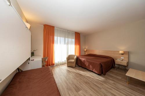 a hotel room with a bed and a window at Hotel Donatello Imola in Imola