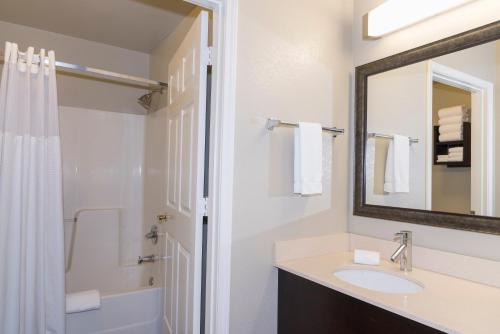 a bathroom with a sink and a shower and a mirror at Staybridge Suites Chicago-Oakbrook Terrace by IHG in Oakbrook Terrace
