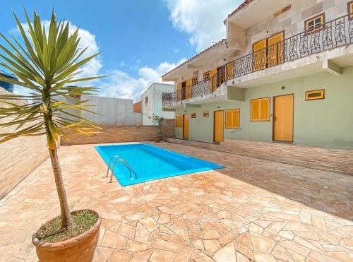 a palm tree in a pot next to a house at Hotel dos Sonhos in São Thomé das Letras