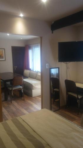 1 dormitorio con cama, sofá y mesa en CASA 2 en San Carlos de Bariloche