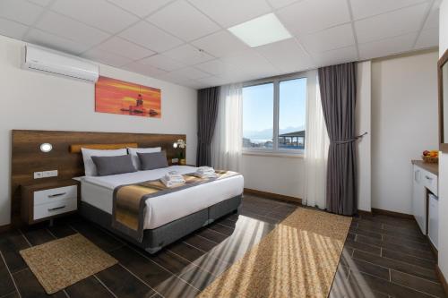 Grand Gulluk Hotel & Spa في أنطاليا: غرفة فندقية بسرير ونافذة كبيرة