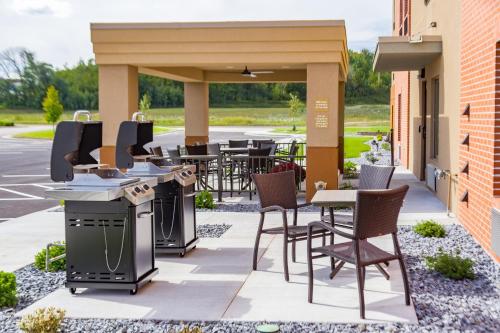 an outdoor patio with tables and chairs and tables with tables and chairsktop at Candlewood Suites Eau Claire I-94 by IHG in Eau Claire
