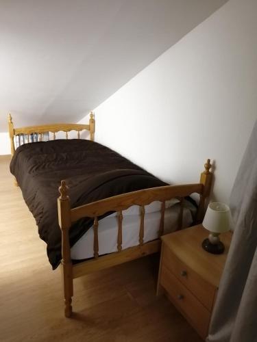 1 dormitorio con cama de madera y mesita de noche en Chez Pat & Mat en La Canourgue