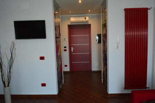a hallway with a red door and a tv on a wall at Una Casa al Belvedere in Enna