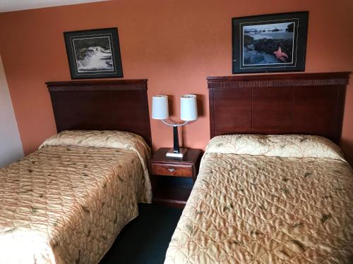 two beds sitting next to each other in a hotel room at Travel Inn in Horseheads