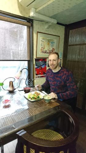a man sitting at a table with a plate of food at Live Cafe Hisui no Umi in Itoigawa