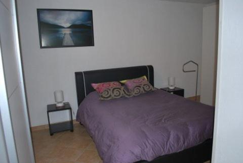 a bedroom with a purple bed with two night stands at Chez Alfred et Régine in Rouffach