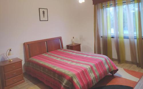 1 dormitorio con 1 cama, vestidor y ventana en Moradia da Graça, en Praia da Vitória