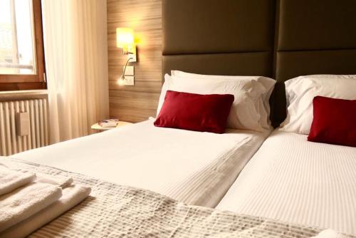 a bedroom with two beds with red pillows at 3 Amici al Teatro in Verona