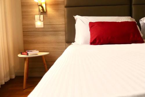 a bed with a red pillow and a side table at 3 Amici al Teatro in Verona