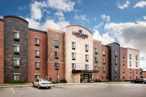a building with a car parked in a parking lot at Candlewood Suites La Crosse by IHG in La Crosse
