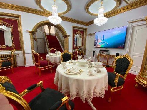 a dining room with tables and chairs and a tv at President Luxury in Ploieşti