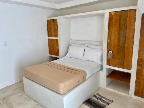 a small bedroom with a bed and a wooden cabinet at MIO Cancún Hotel Boutique in Cancún