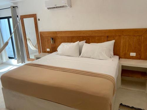 a bed with white sheets and pillows in a room at MIO Cancún Hotel Boutique in Cancún