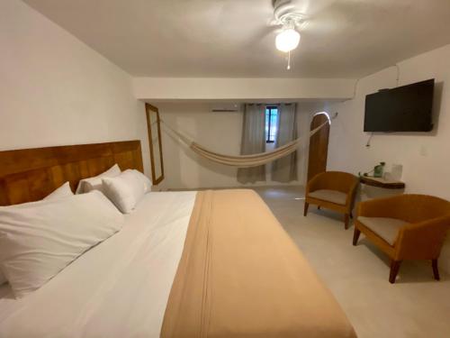 a bedroom with a bed and a tv and a chair at MIO Cancún Hotel Boutique in Cancún